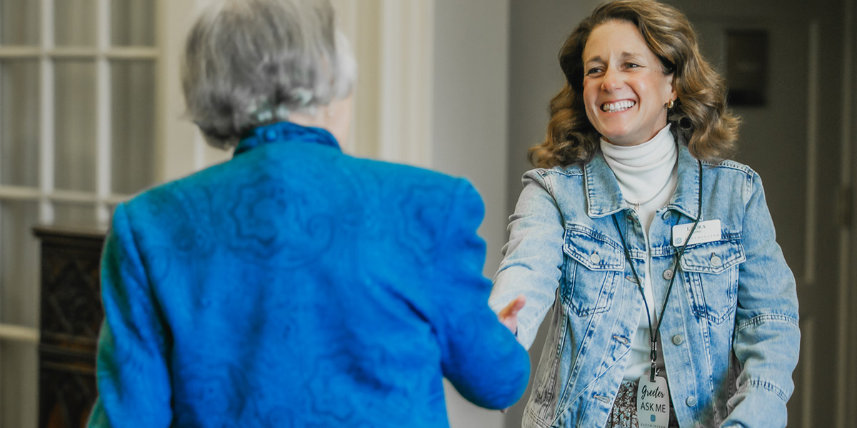 two women shaking hands serve